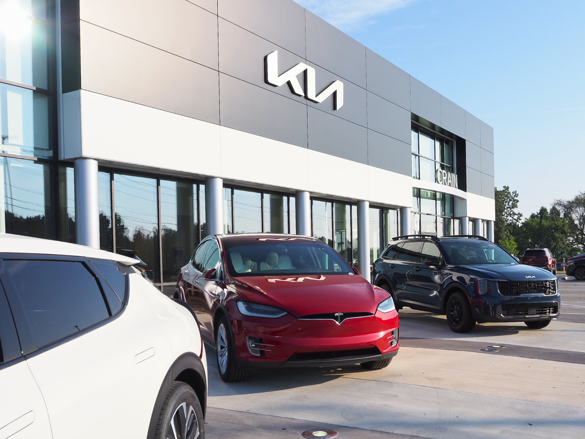 Tesla and Kia Sorento Outside Crain Kia of Fayetteville Building