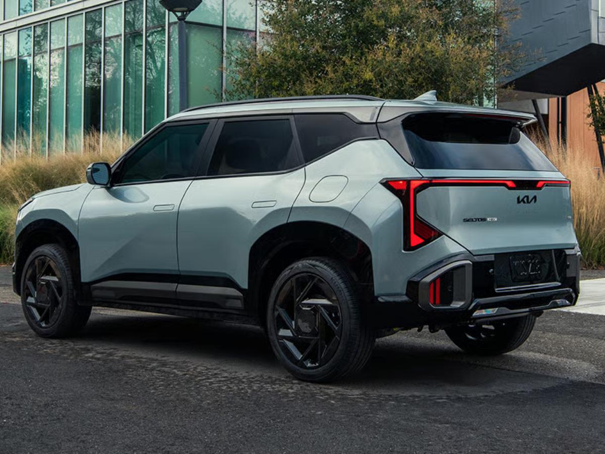 Light gray 2027 Kia Seltos parked outside a modern building
